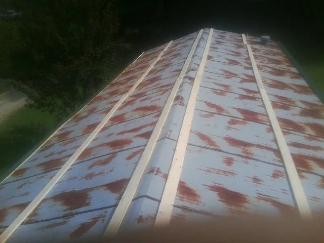 Rusted metal roof panels with new wood purlins before replacement — Storm Damage Roof Repair in Fox Lake by Roofing Brothers